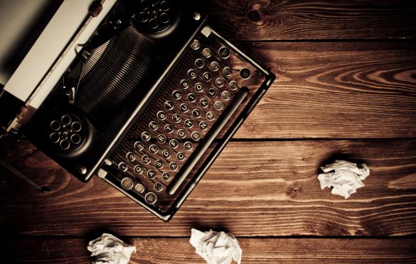 a typewriter with discarded paper around it