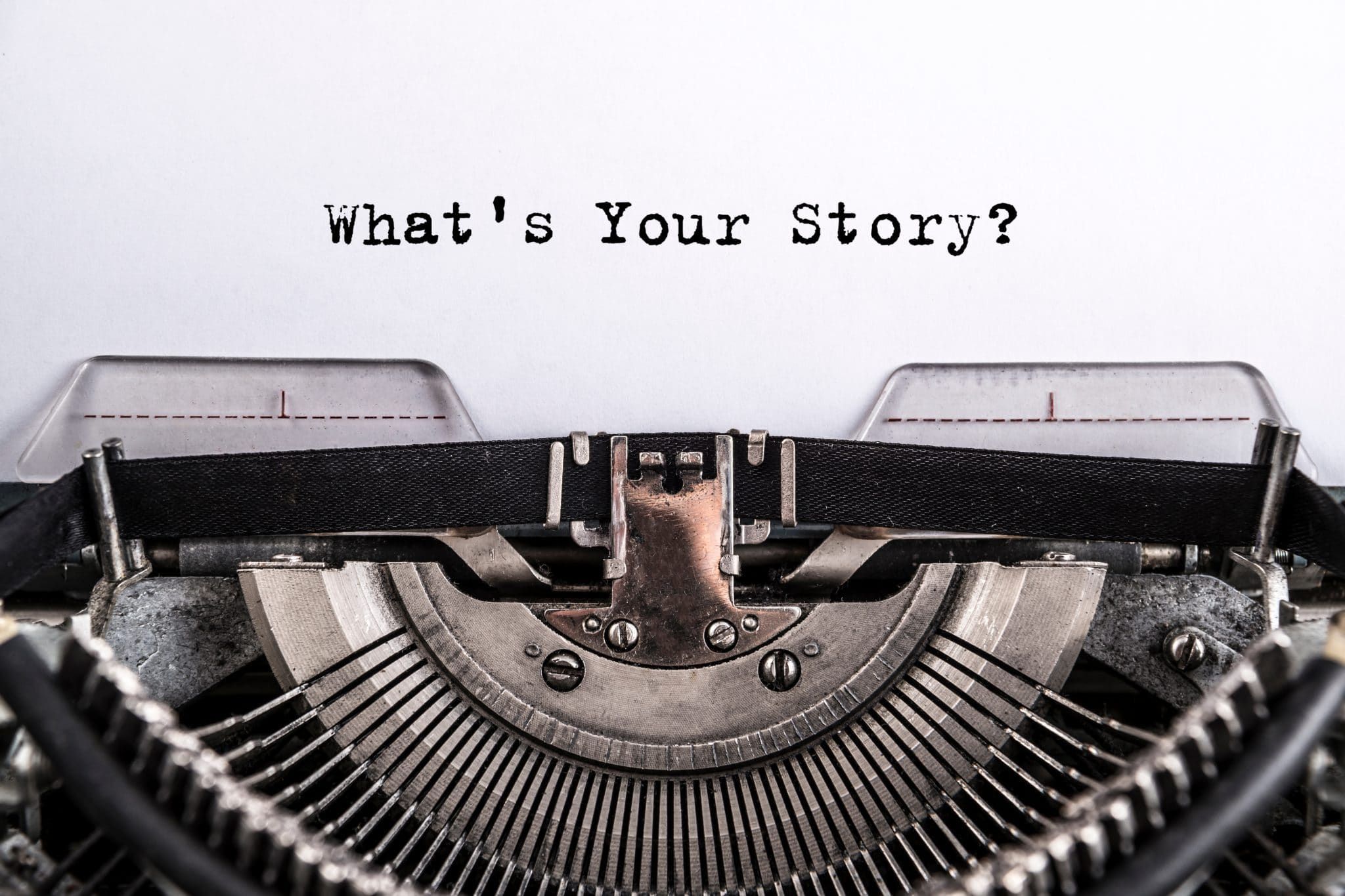 typewriter with 'what's your story?' text