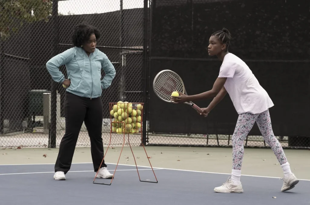 Aunjanue Ellis teaches Demi Singleton how to serve on the tennis court 