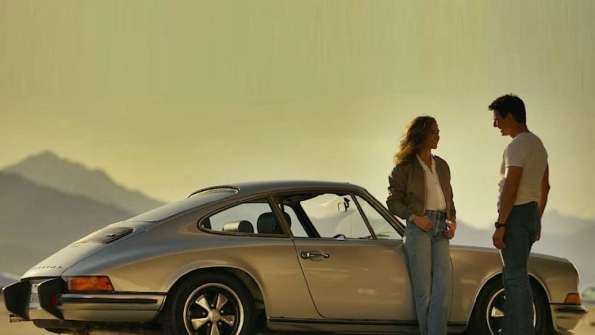 Jennifer Conolly and Tom Cruise stand by their car in Top Gun: Maverick