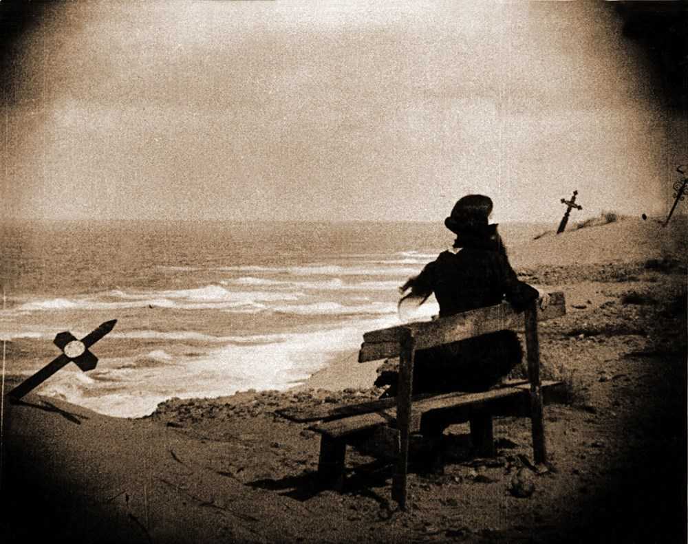 Ellen sits on a bench at the shore in Nosferatu