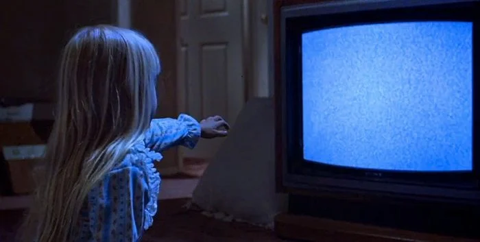 little girl watches a blank TV