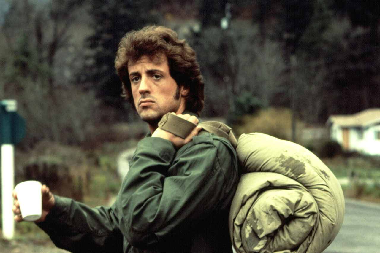Sylvester Stallone with a rolled-up sleeping bag on his back in First Blood