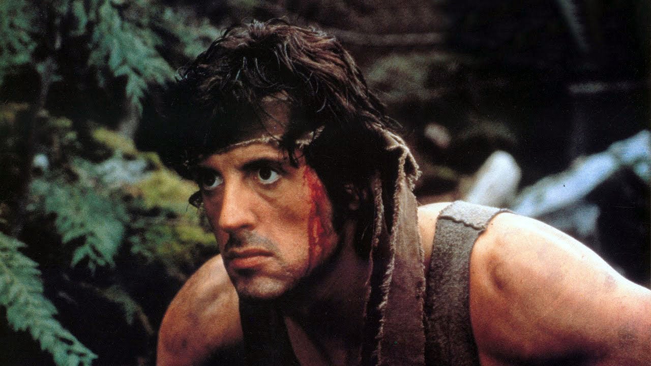 Stallone as Rambo in the jungle with blood running down the side of his face