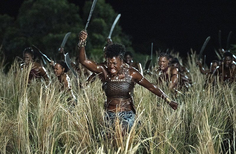 Nanisca leads her warriors through a hayfield, her weapon raised in the air