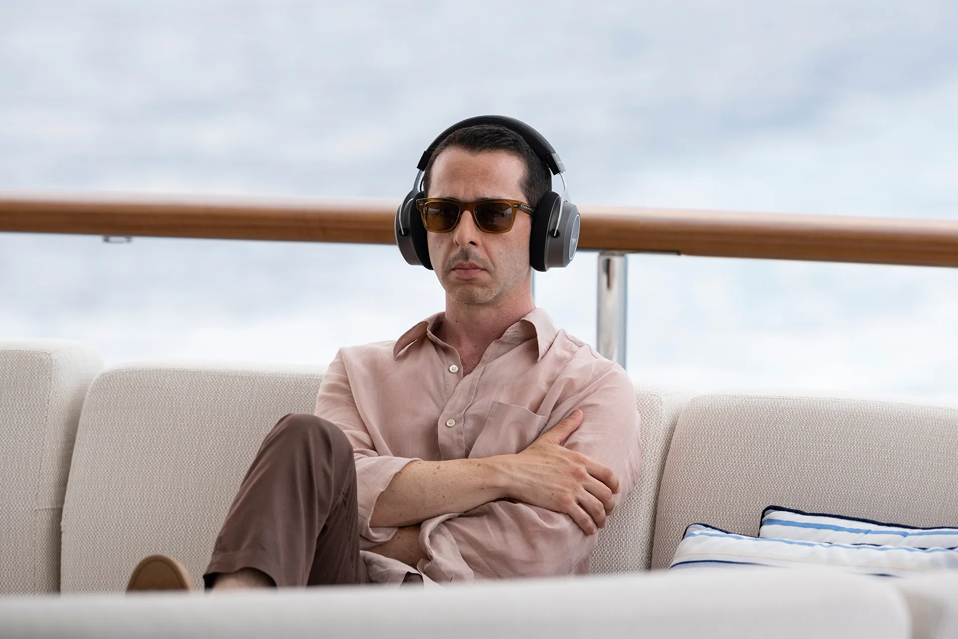 Jeremy Strong as Kendall Roy, sitting on a coach on a yacht, wearing sunglasses