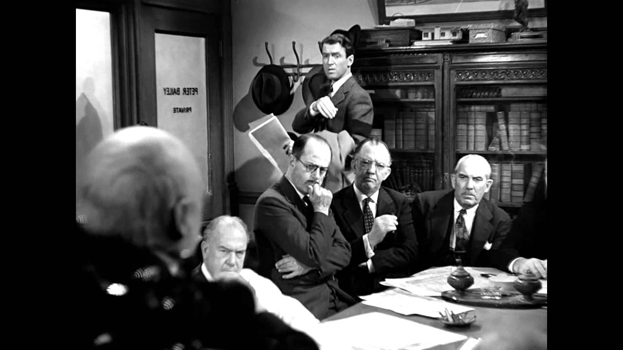 George in the board room with men in suits.