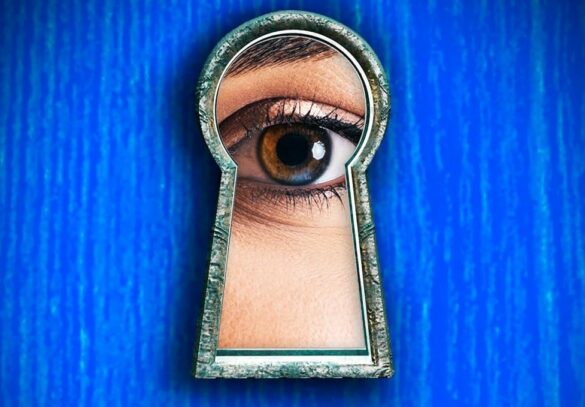 An eye stares through a key lock