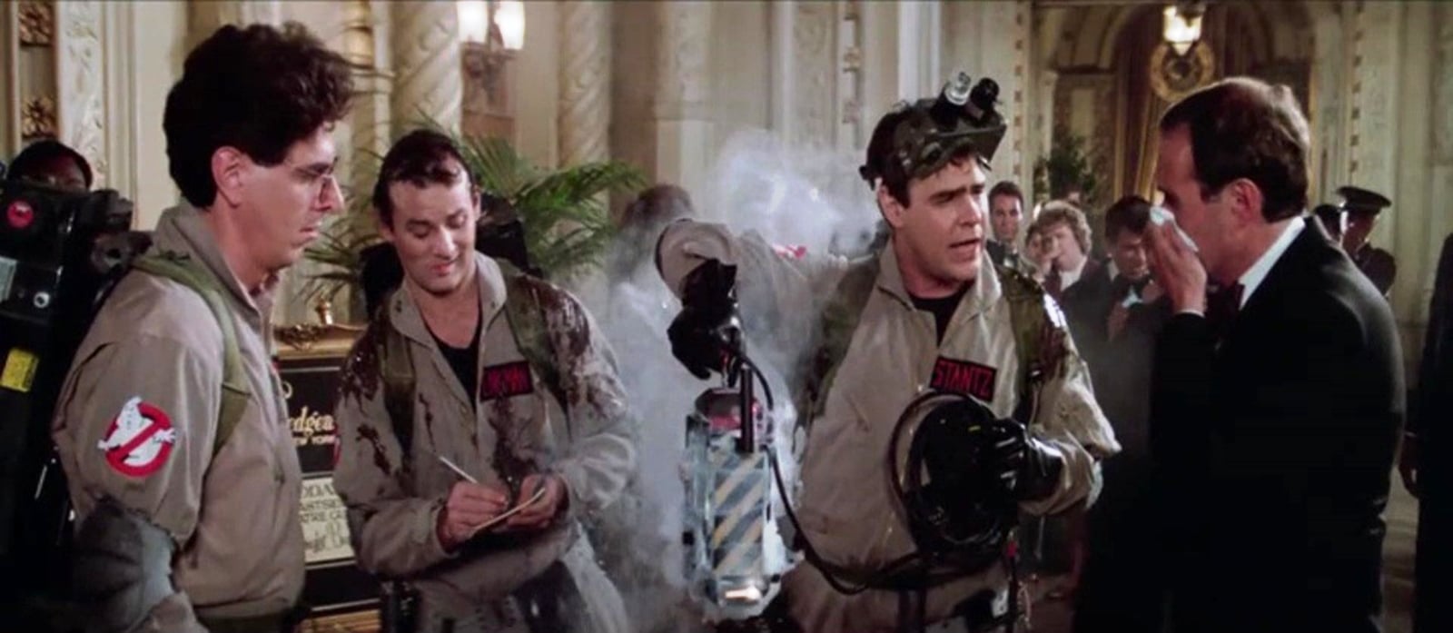 smoke is in the air as the 3 ghostbusters deploy a trap