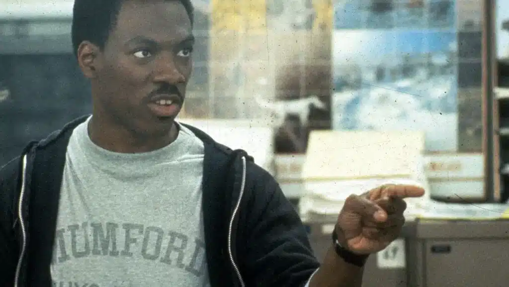 Eddie Murphy sitting at his desk pointing