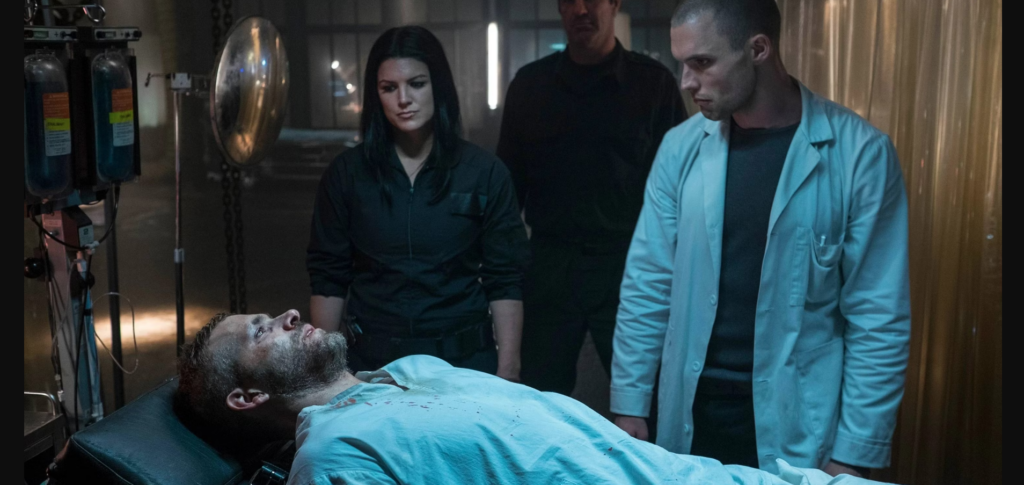 Wade lies on a gurney as Francis stands next to him