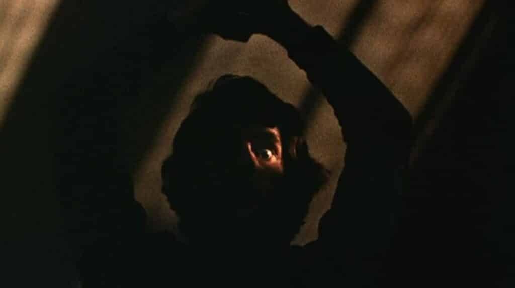 A silhouette holding a knife over its head