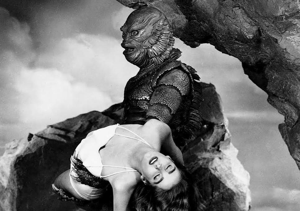 The Creature holds Kay, who has fainted