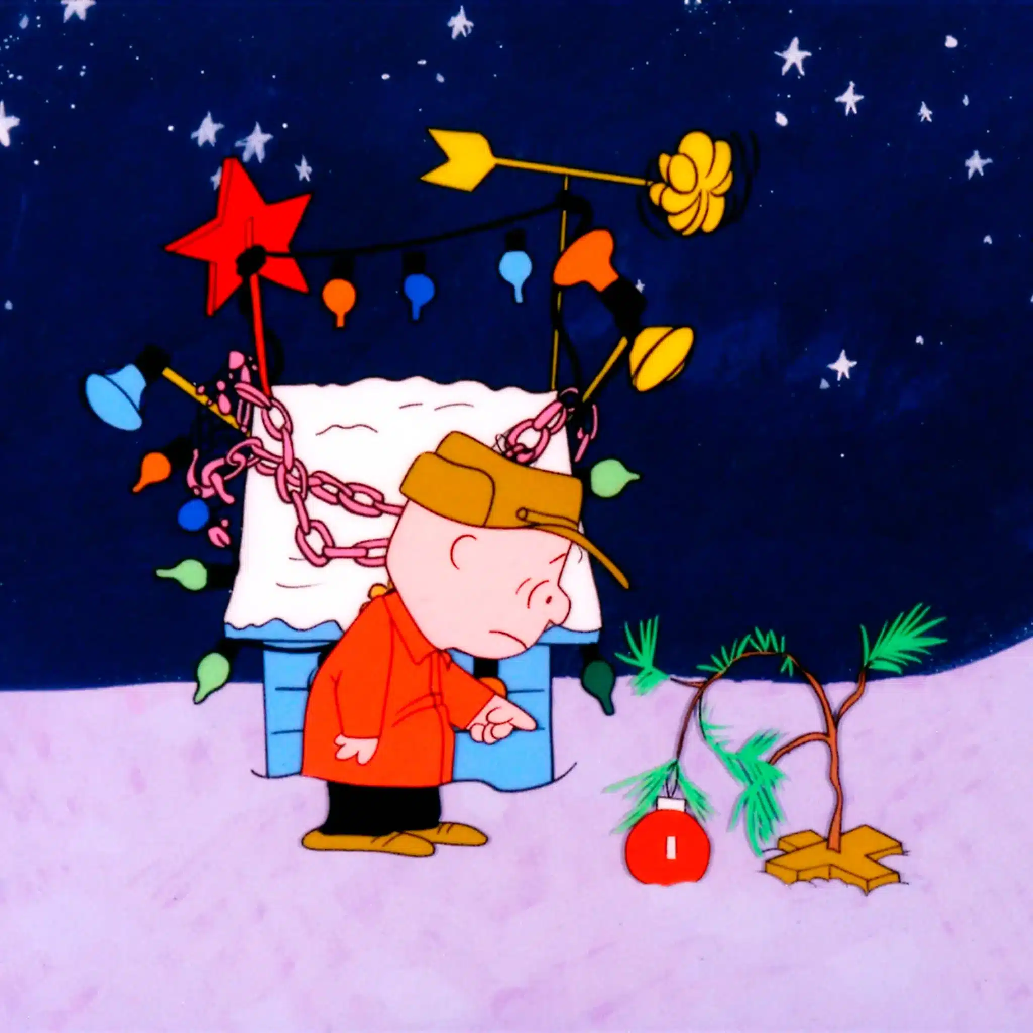 A dejected Charlie Brown stands over his bent Christmas sapling.