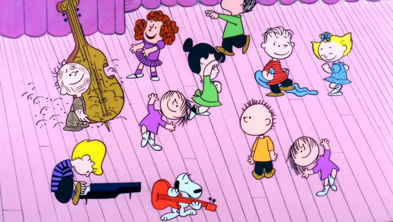 The Peanuts characters dancing on the floor of the auditorium