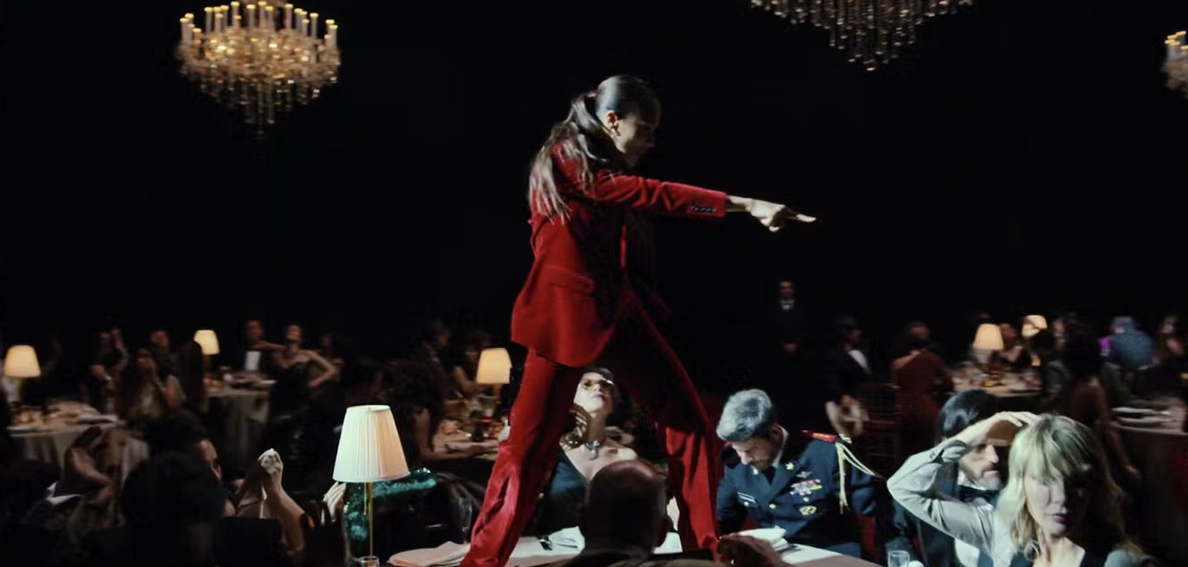 Rita dancing on a table top while diners look up at her