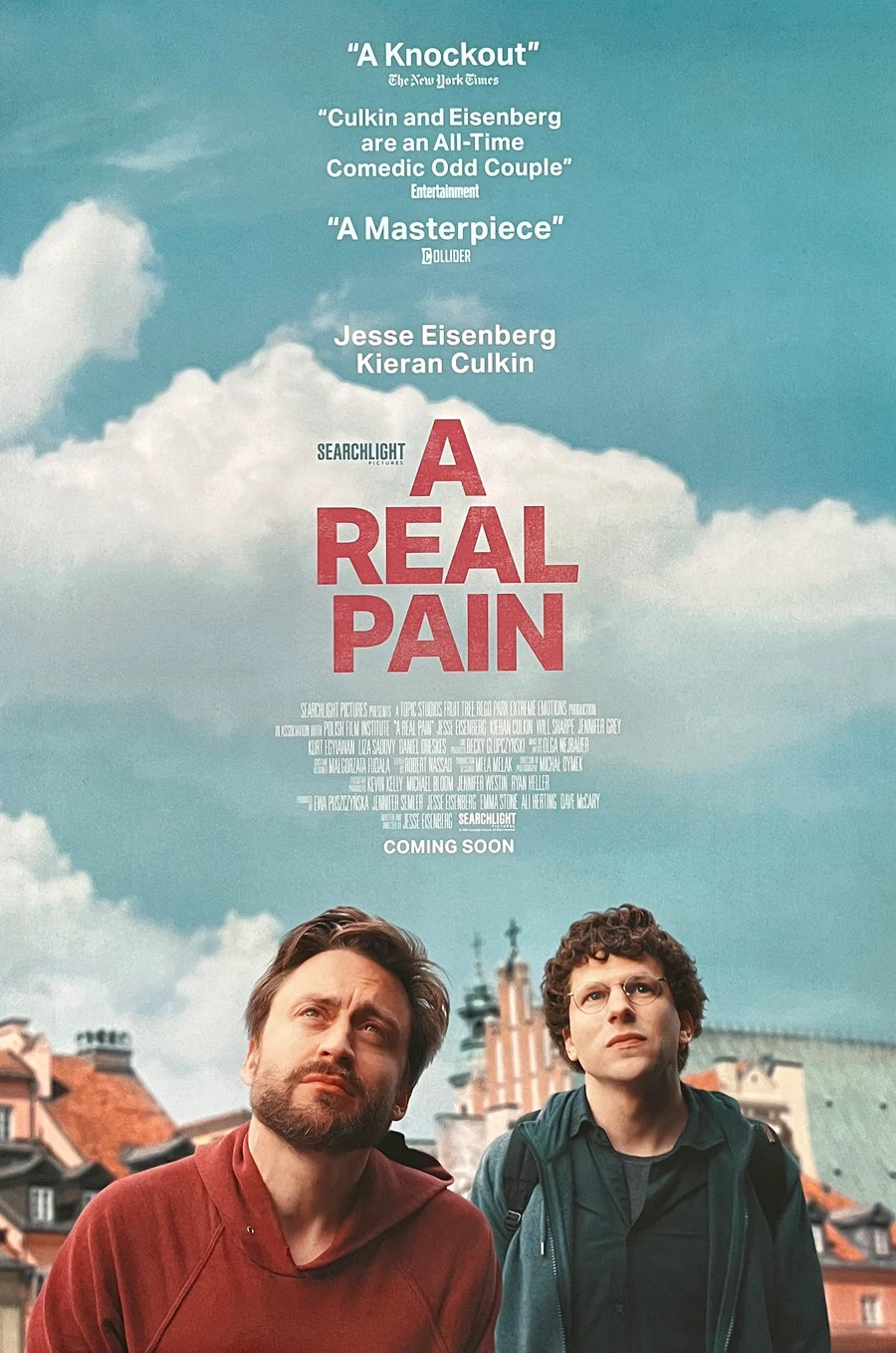 Kieran Culkin and Jesse Eisenberg standing with the sky behind them in the poster for the movie A Real Pain