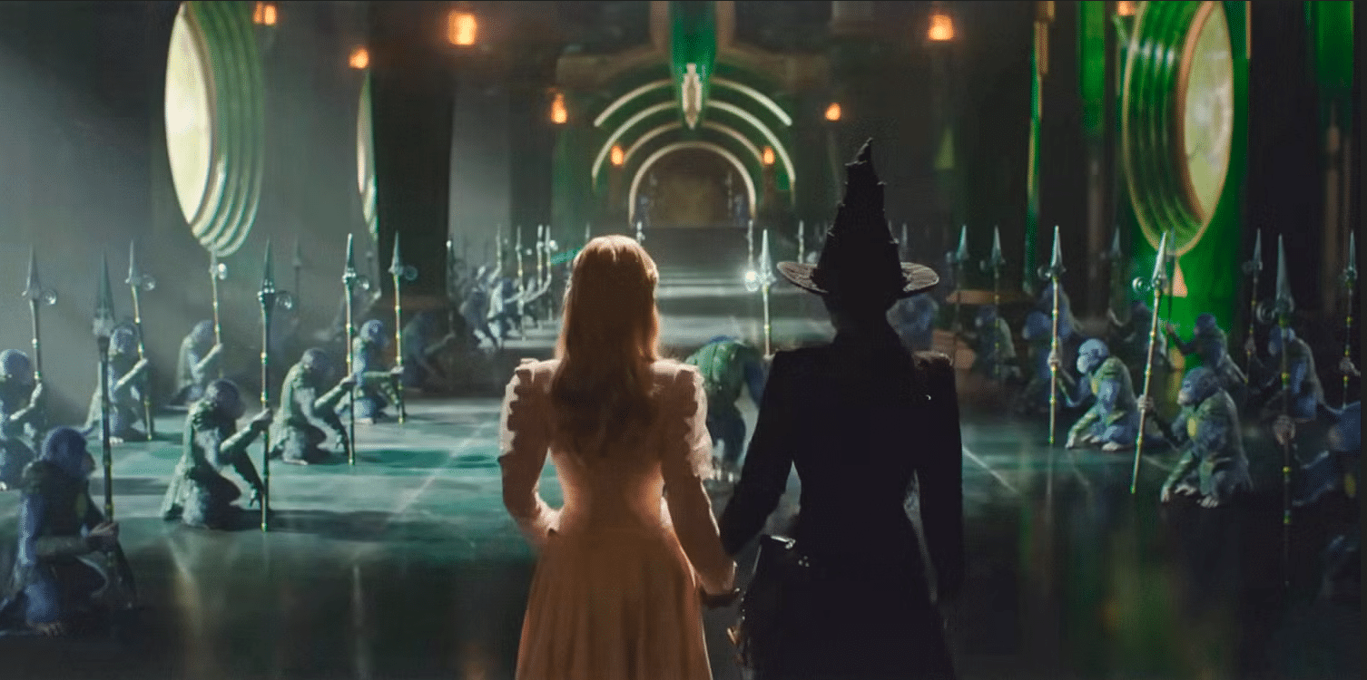 Galinda and Elphaba holding hands as they enter the Wizard's castle