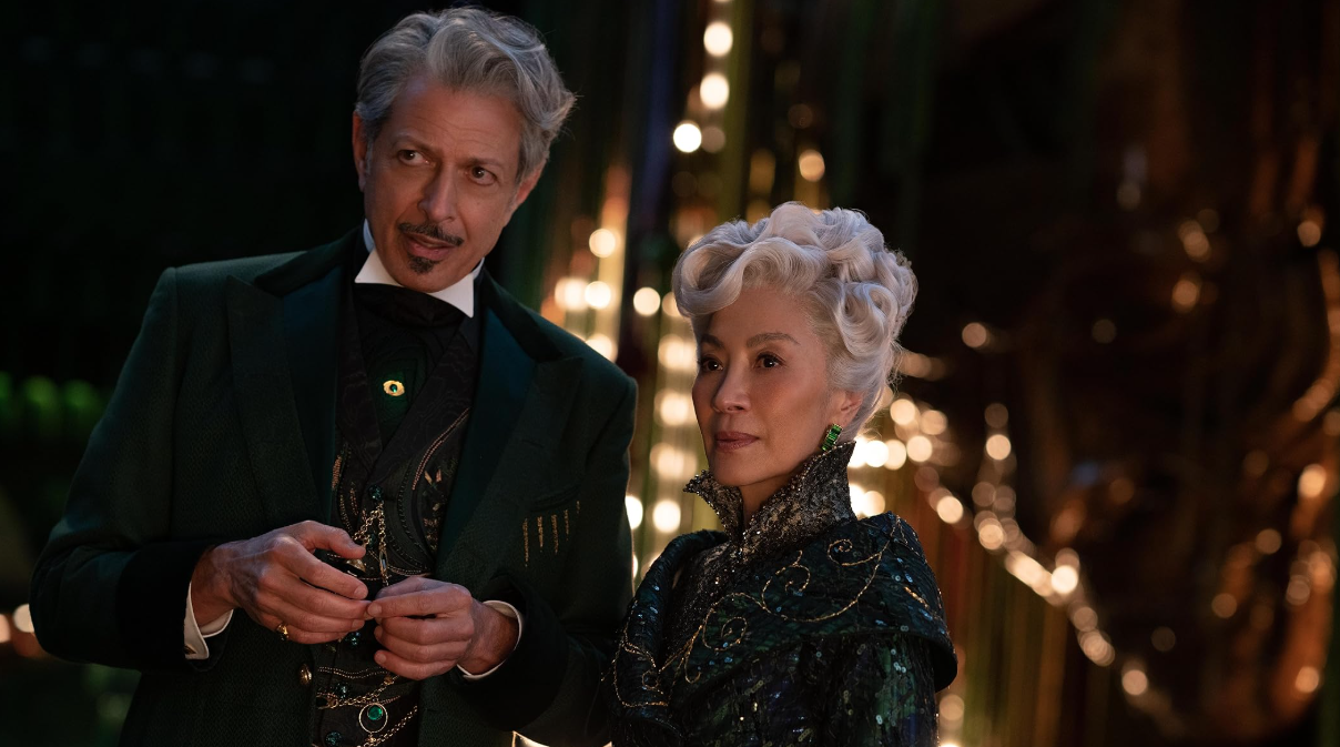 The Wizard and Morrible standing together in the nightime in Oz