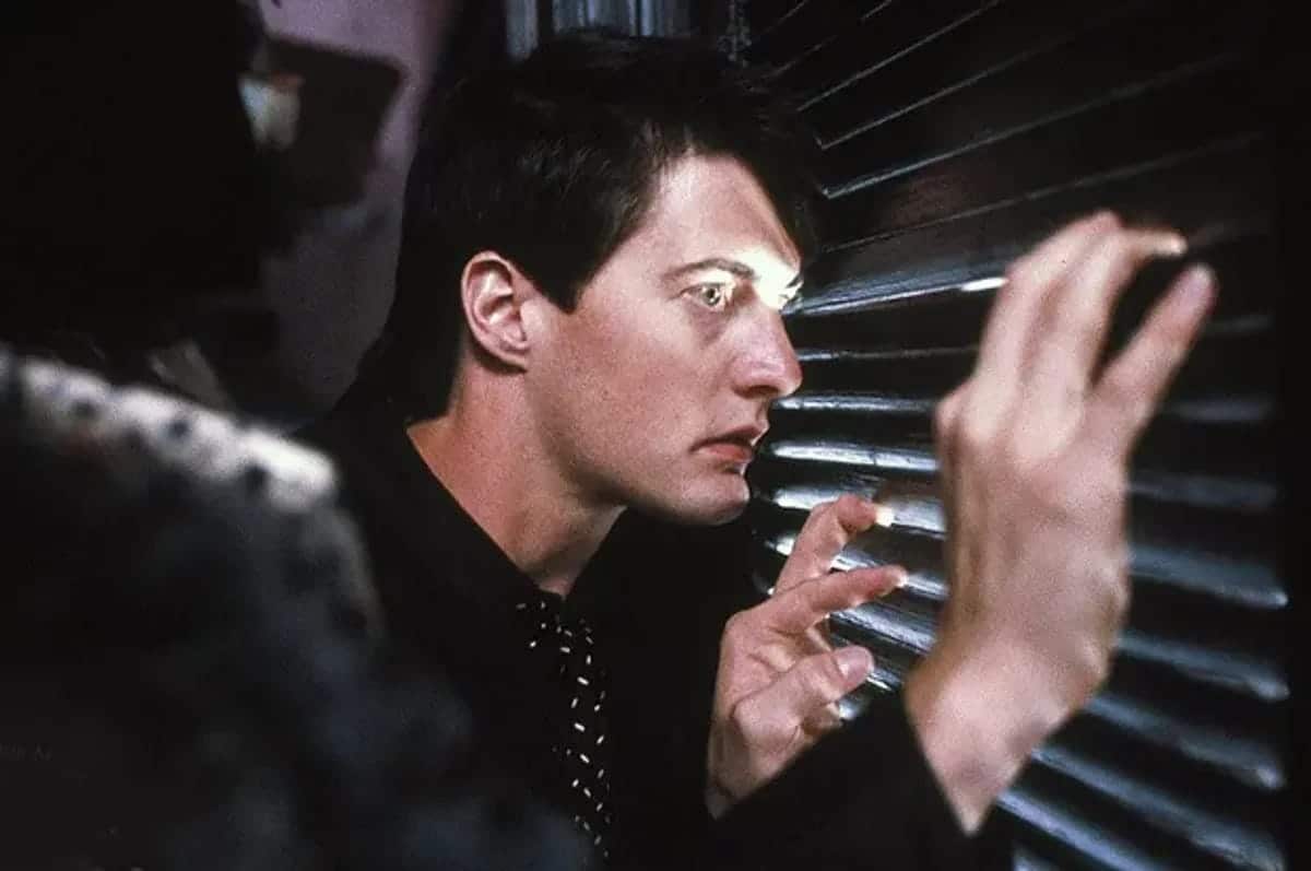Kyle MacLachlan peeks between the louvers of a door