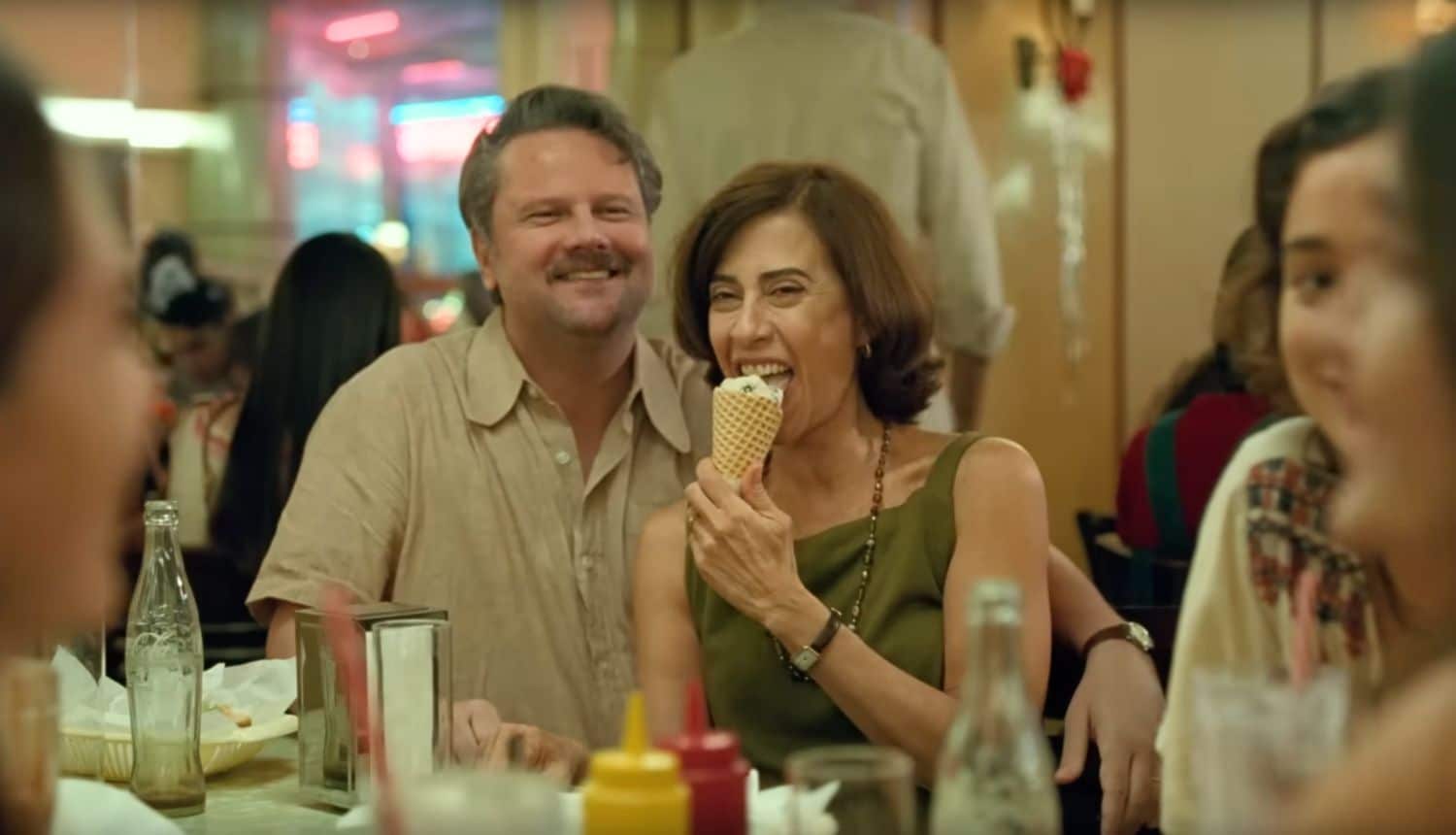 Eunice holding an ice cream cone while Ruben and the family sit at the restaurant table