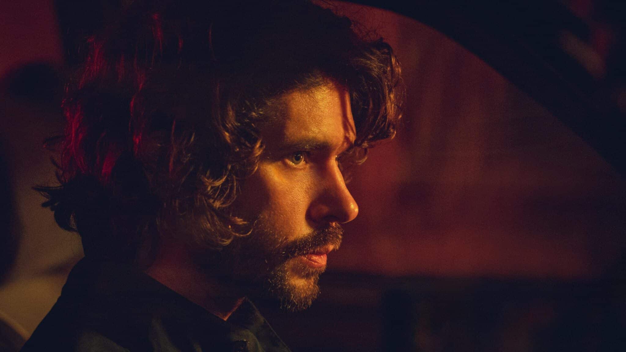 Ben Whishaw looking straight ahead in the dark night