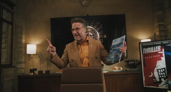 Seth Rogan as Matt Remick in The Studio, standing behind his desk holding a deck and pointing