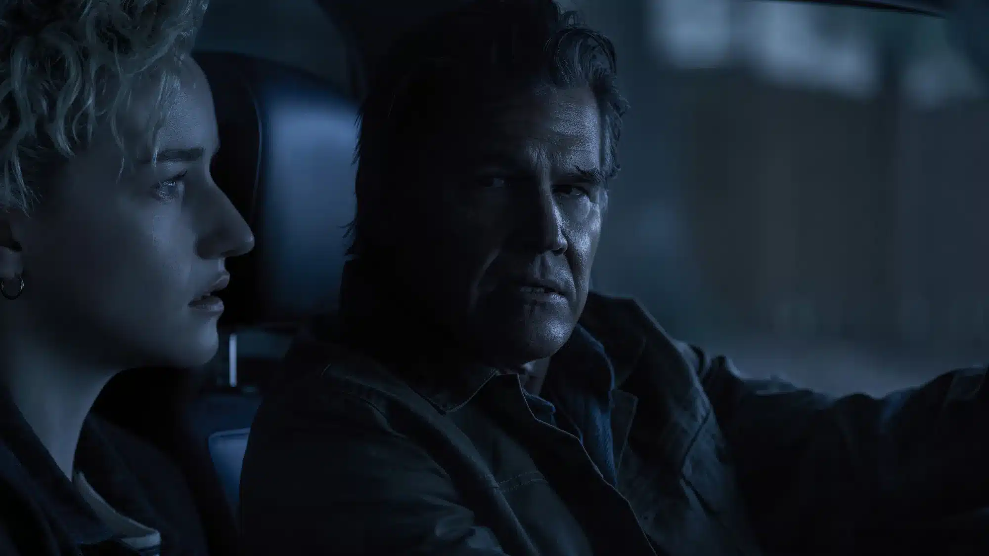 Julia Garner and Josh Brolin in the front seat of a car at night