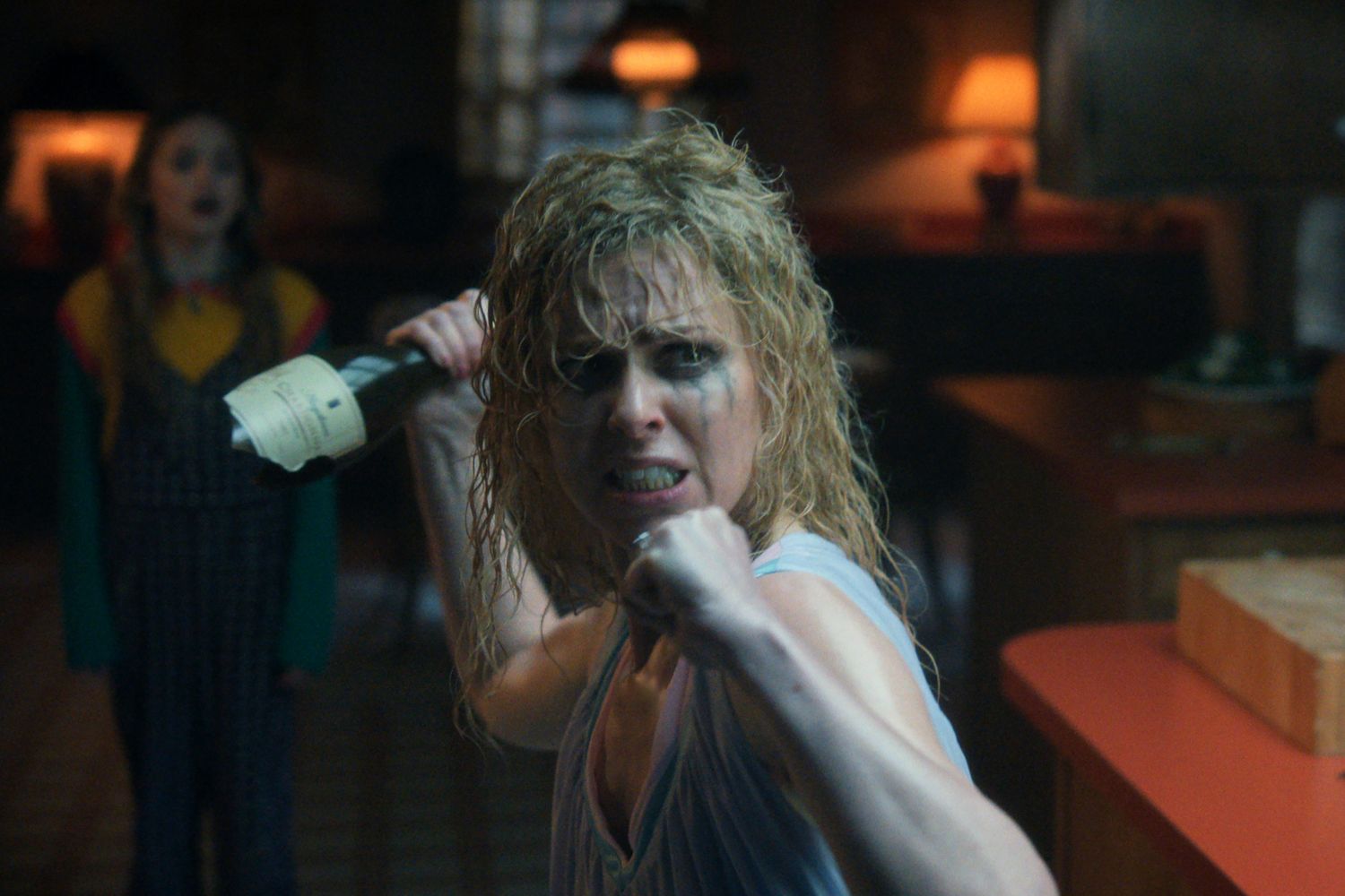 Karen Wheeler holding a broken bottle, ready to attack