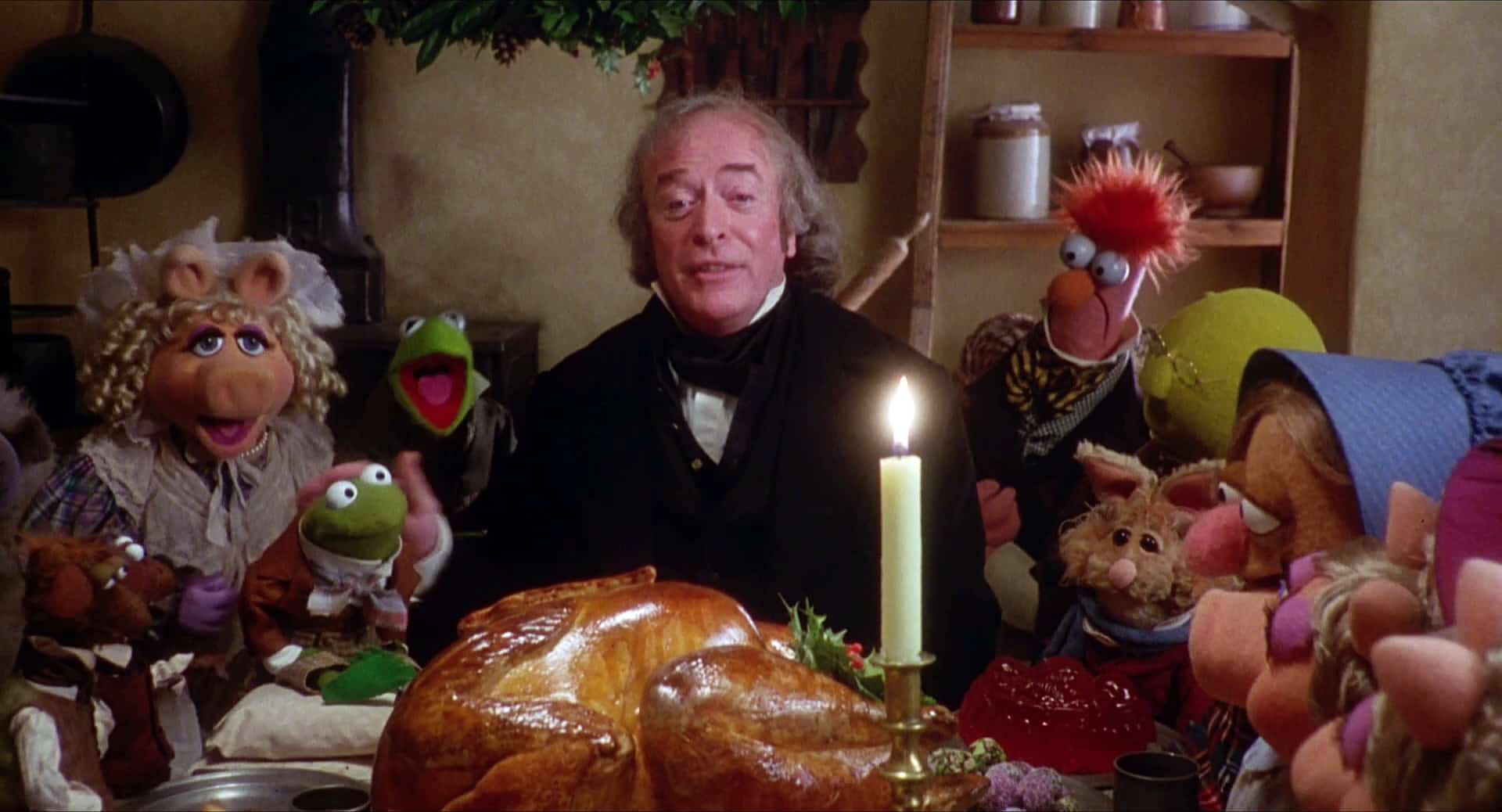 Scrooge eats a beautiful turkey dinner at a festive table with the Muppets