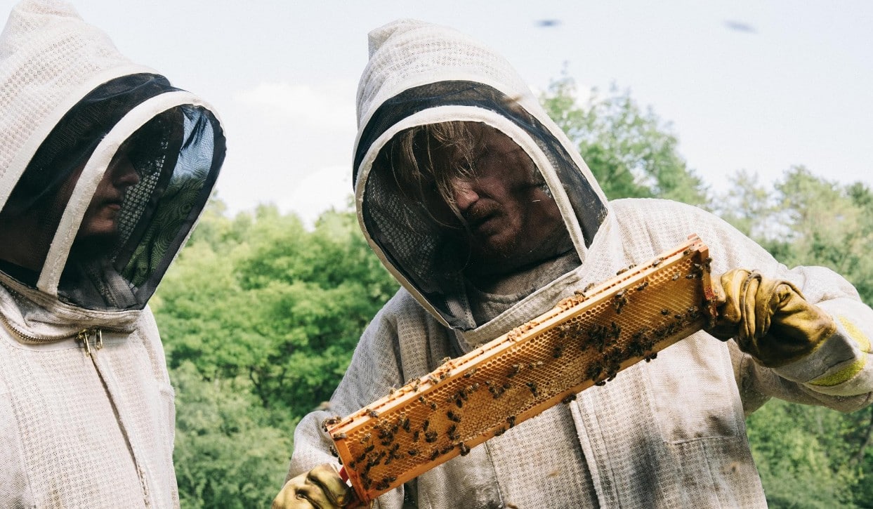 Don and Teddy look over the bees hive Teddy is holding