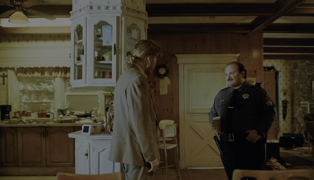 Teddy talks to the policeman Casey in his dining room