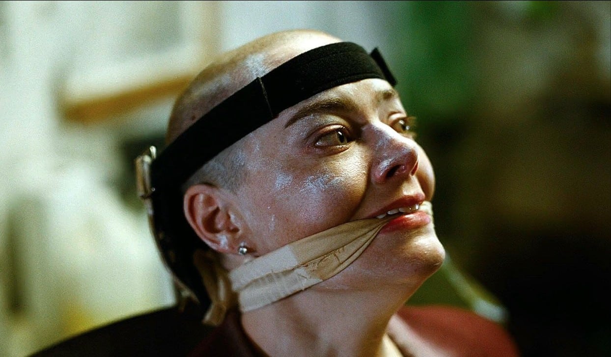 Michelle strapped to a chair with a gag over her mouth