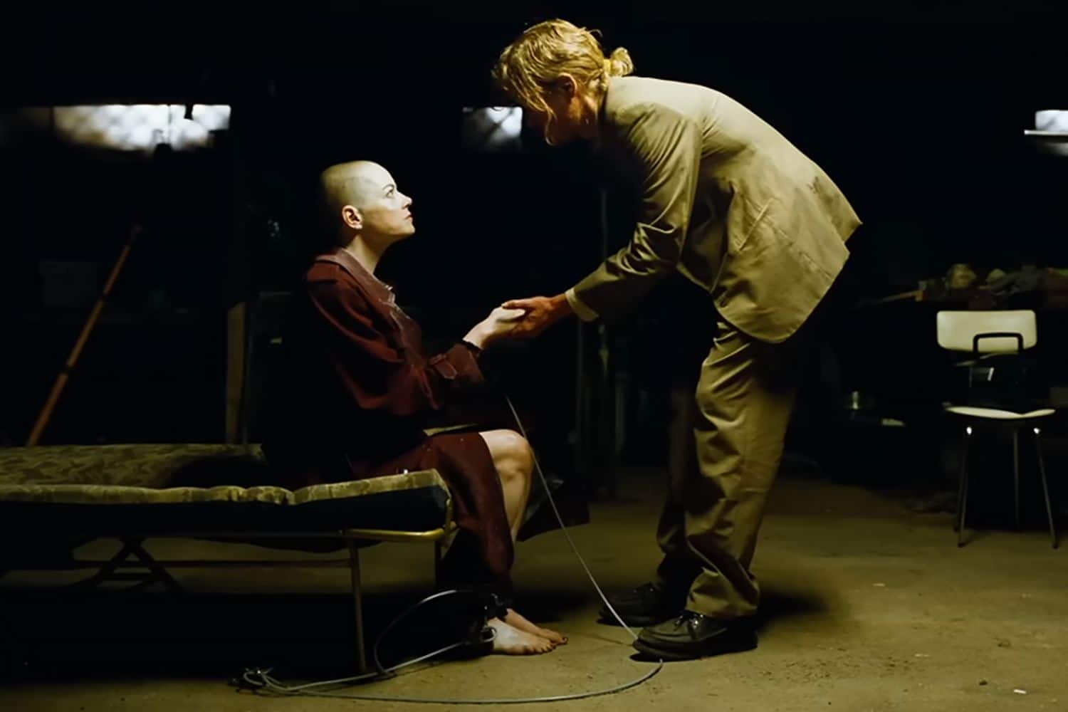 Teddy talks with MIchelle, who's secured to a chair in Teddy's basement