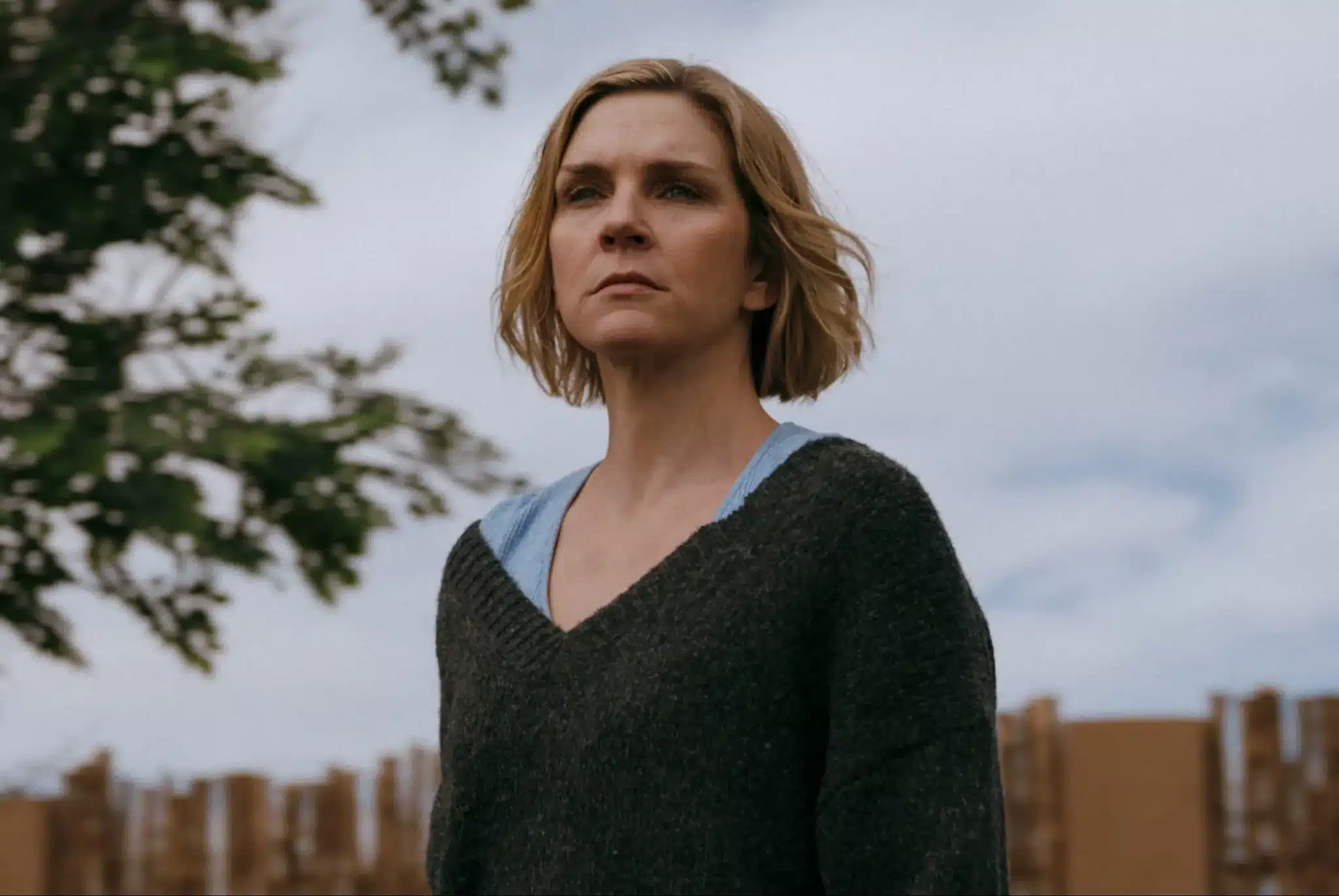 Rhea Seehorn stands alone outside looking forlorn in the pilot of Pluribus