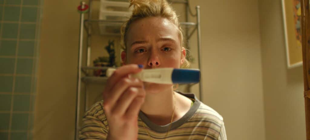 Elle Fanning stares at her pregnacy tester