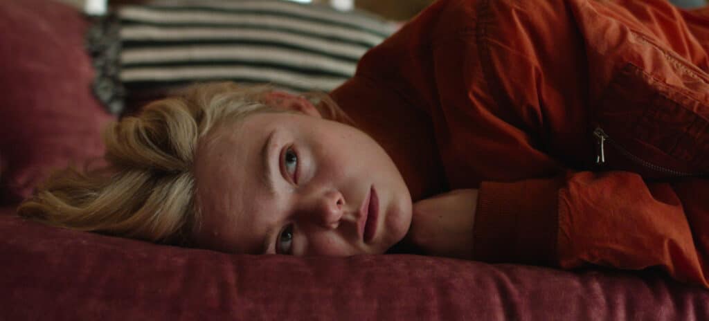 Elle Fanning laying on a couch