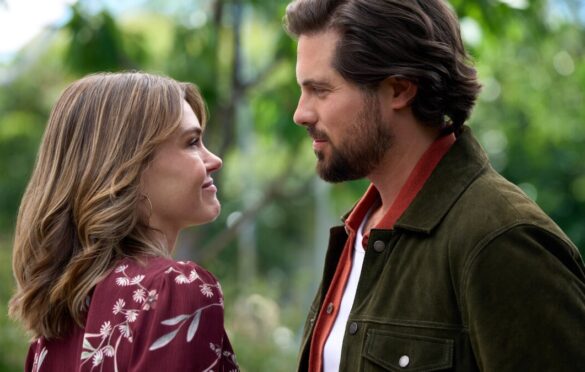 Aimeé Teegarden and Chris McNally staring at each other in a forest