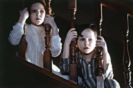The 2 children look through the staircase